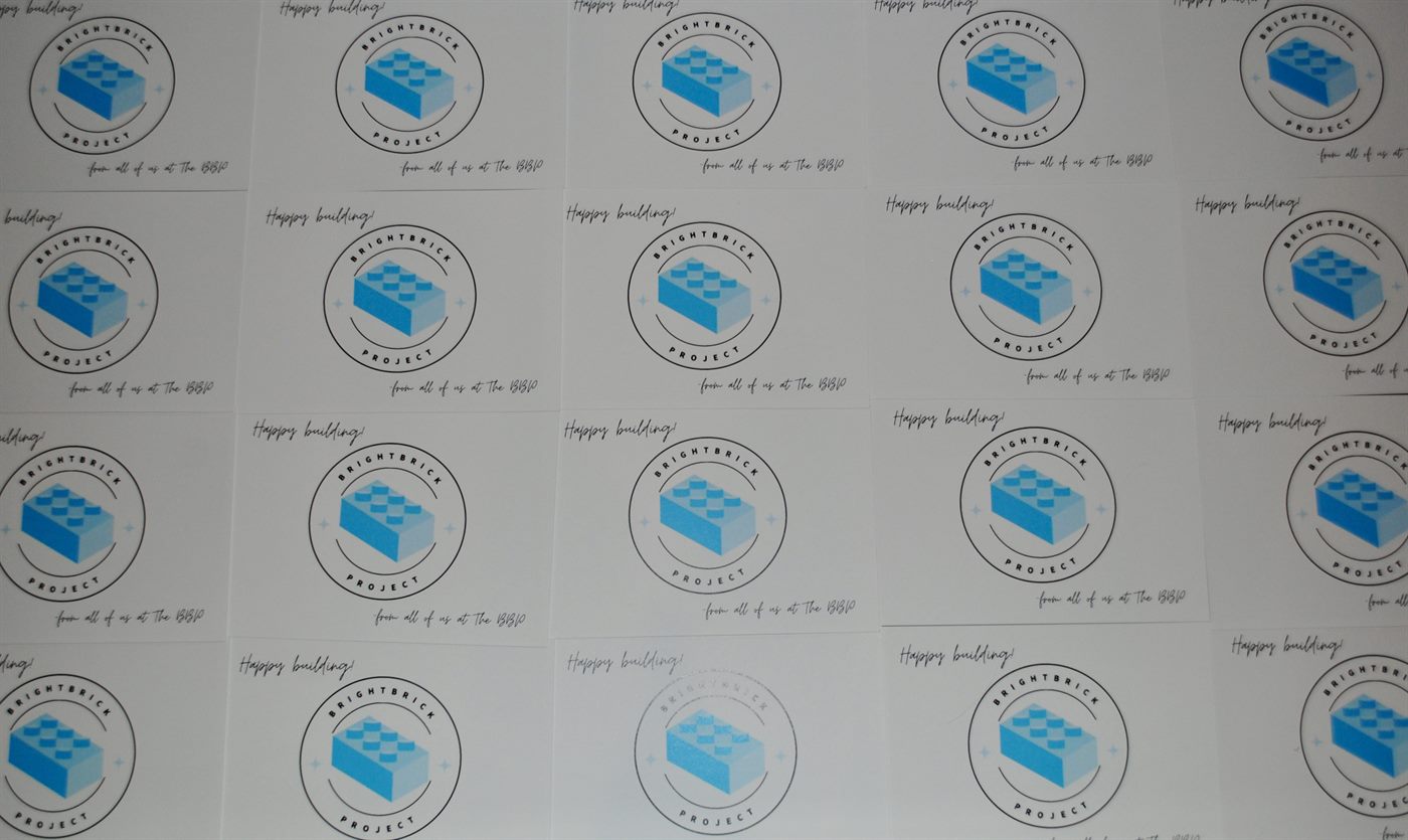 A grid of The BrightBrick Project's 'Happy building' cards, each featuring the logo, ready to go out with delivered LEGO sets.